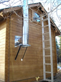 installation of a stove pipe off of the back of a custom cabin kit from bavariancottages.com